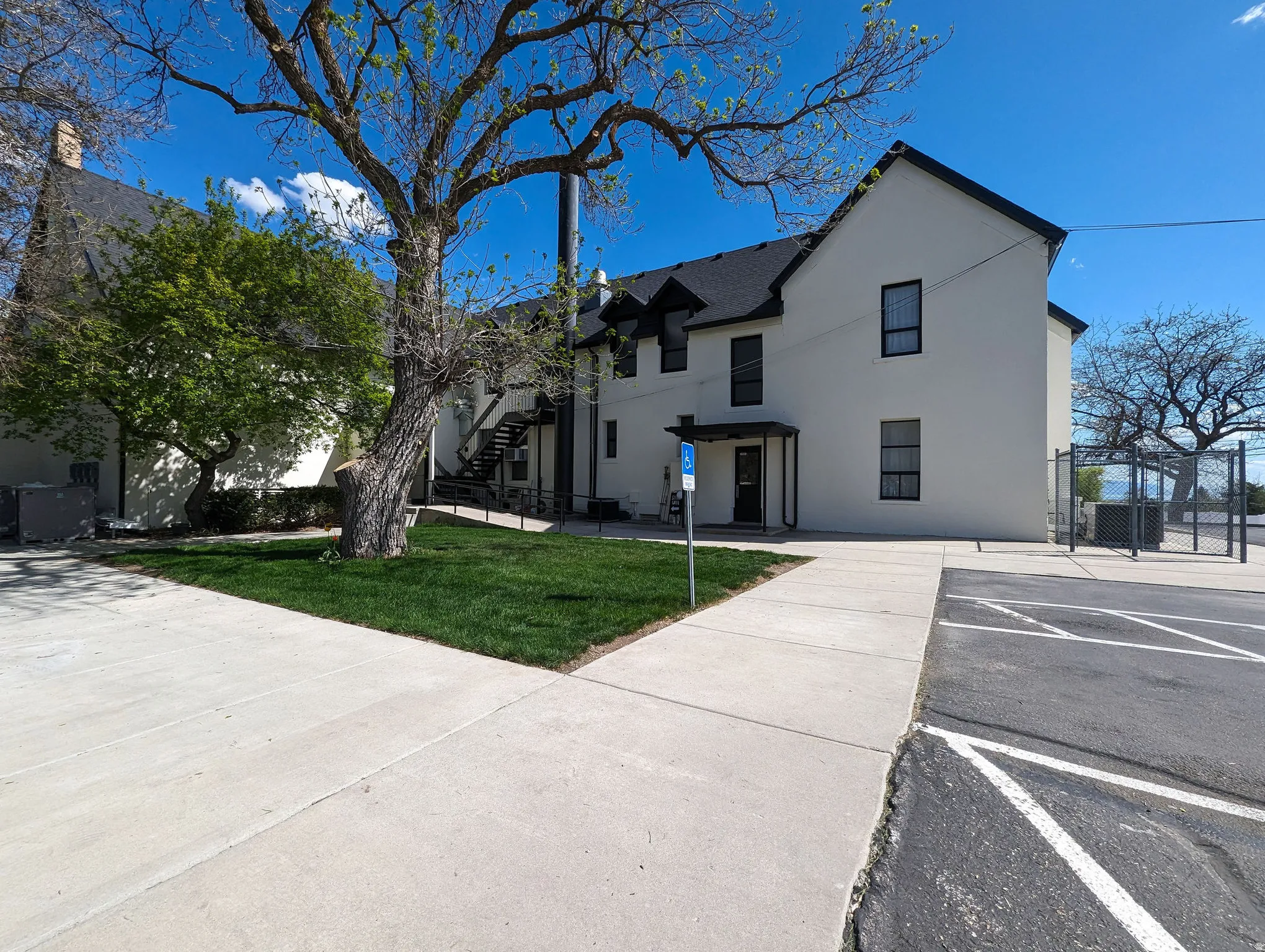 View of building exterior with uncovered parking and stairs