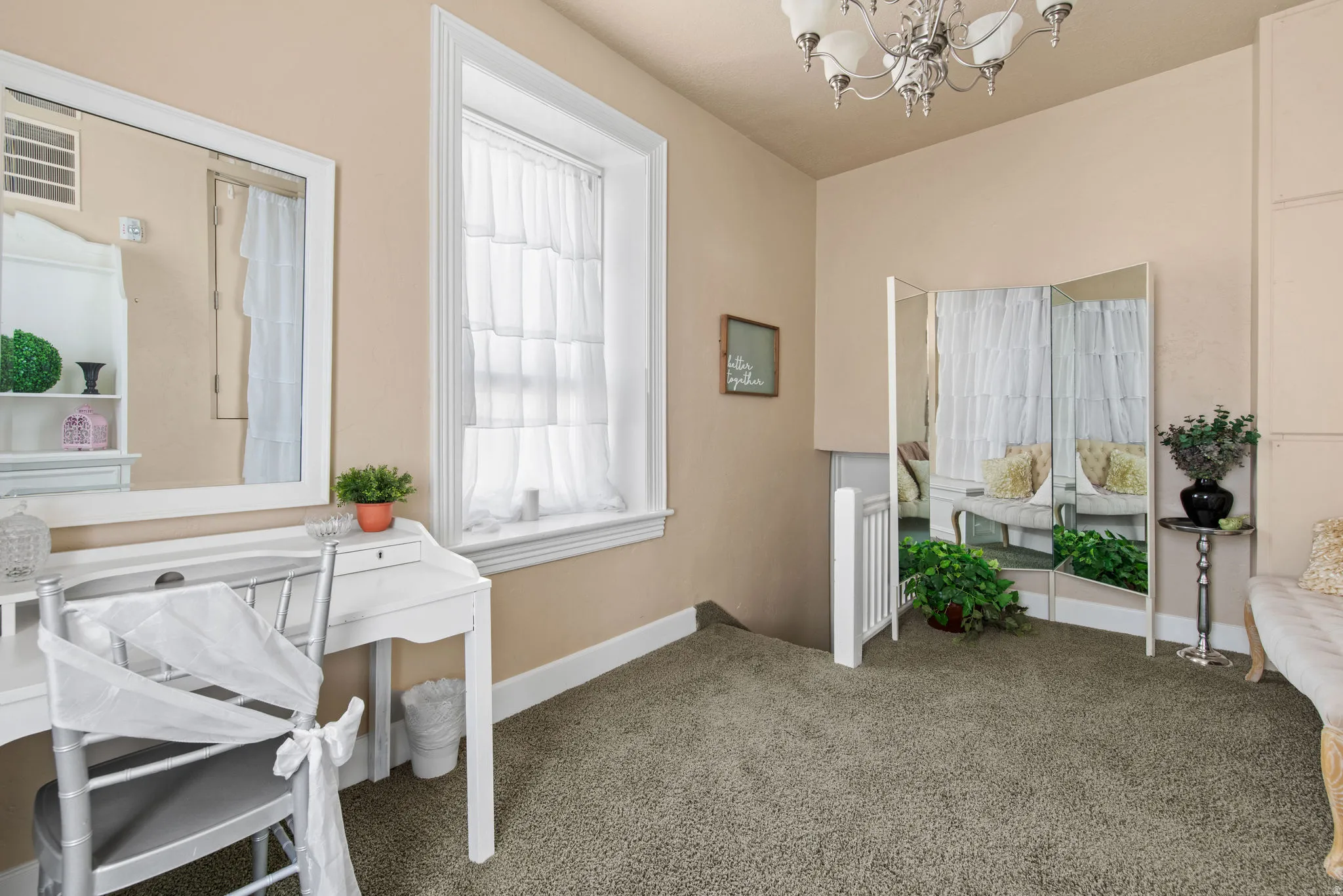 Carpeted office space featuring a chandelier and baseboards
