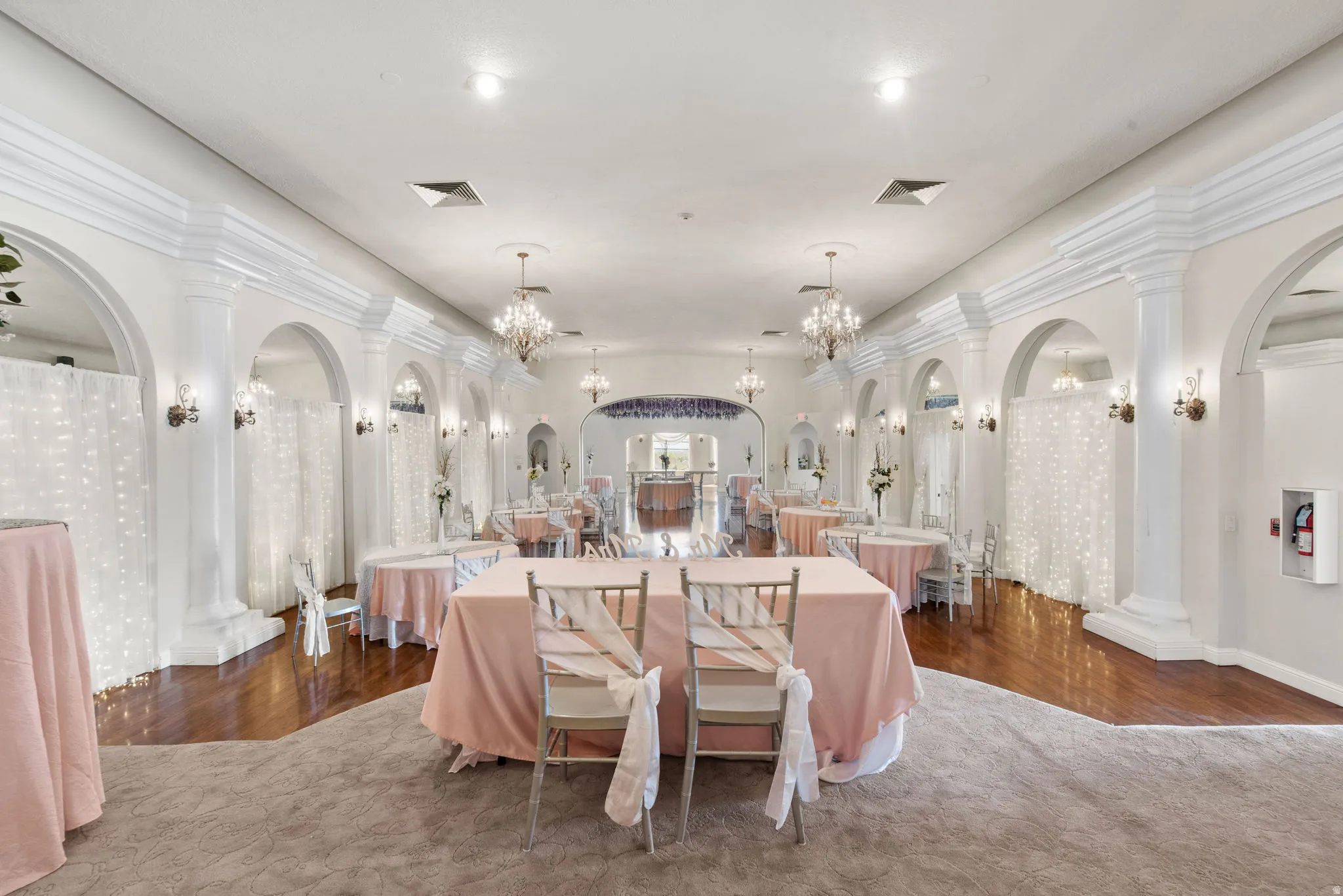 Dining room featuring arched walkways, a chandelier, and dark wood-type flooring