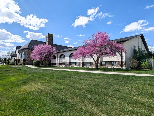 View of front of property with a front lawn, a chimney, and stucco siding