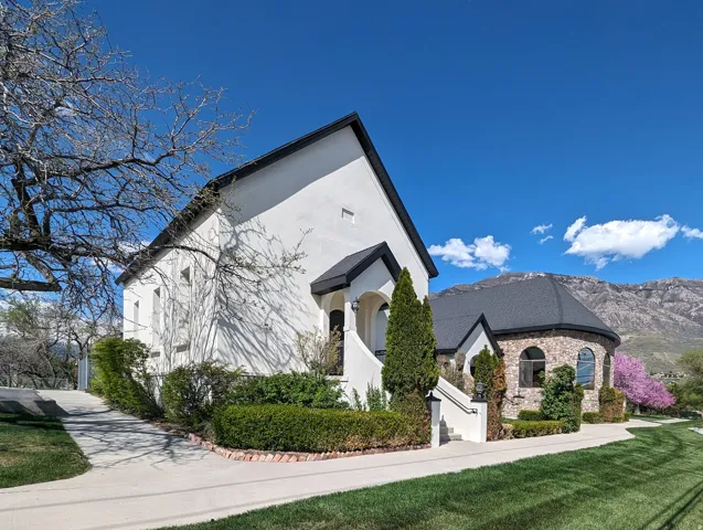 View of front of property with stucco siding, stone siding, and a mountain view