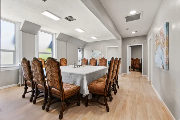 Dining room with a textured ceiling, light wood-style flooring, and radiator heating unit