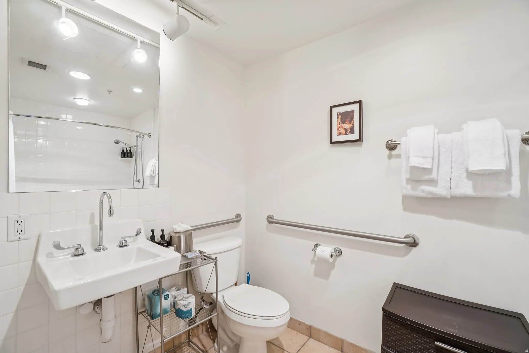 Full bath with backsplash, rail lighting, and a shower