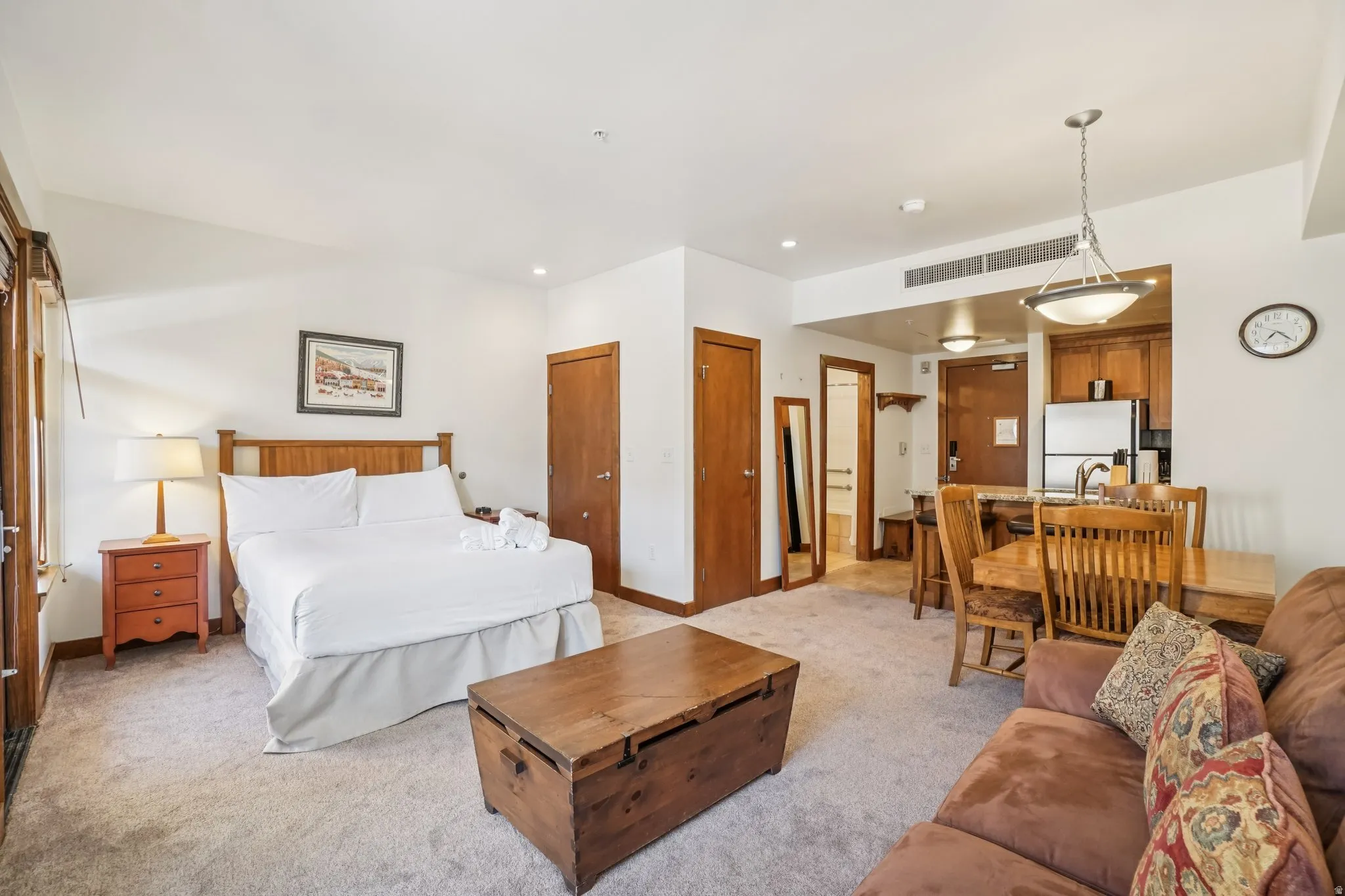 Bedroom featuring two closets, carpet floors, and freestanding refrigerator
