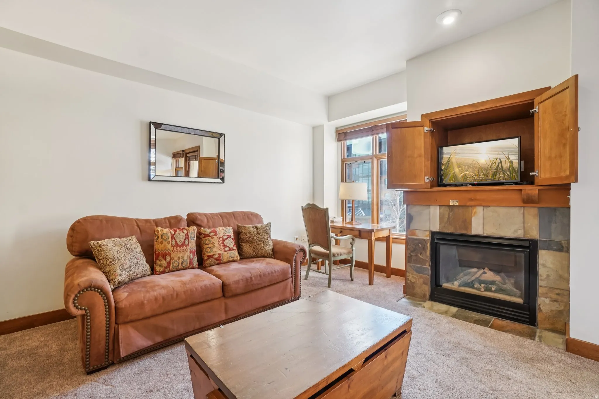 Living room featuring light carpet and a tiled fireplace