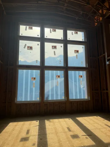 Floor-to-ceiling multi-pane windows with mountain scenery backdrop