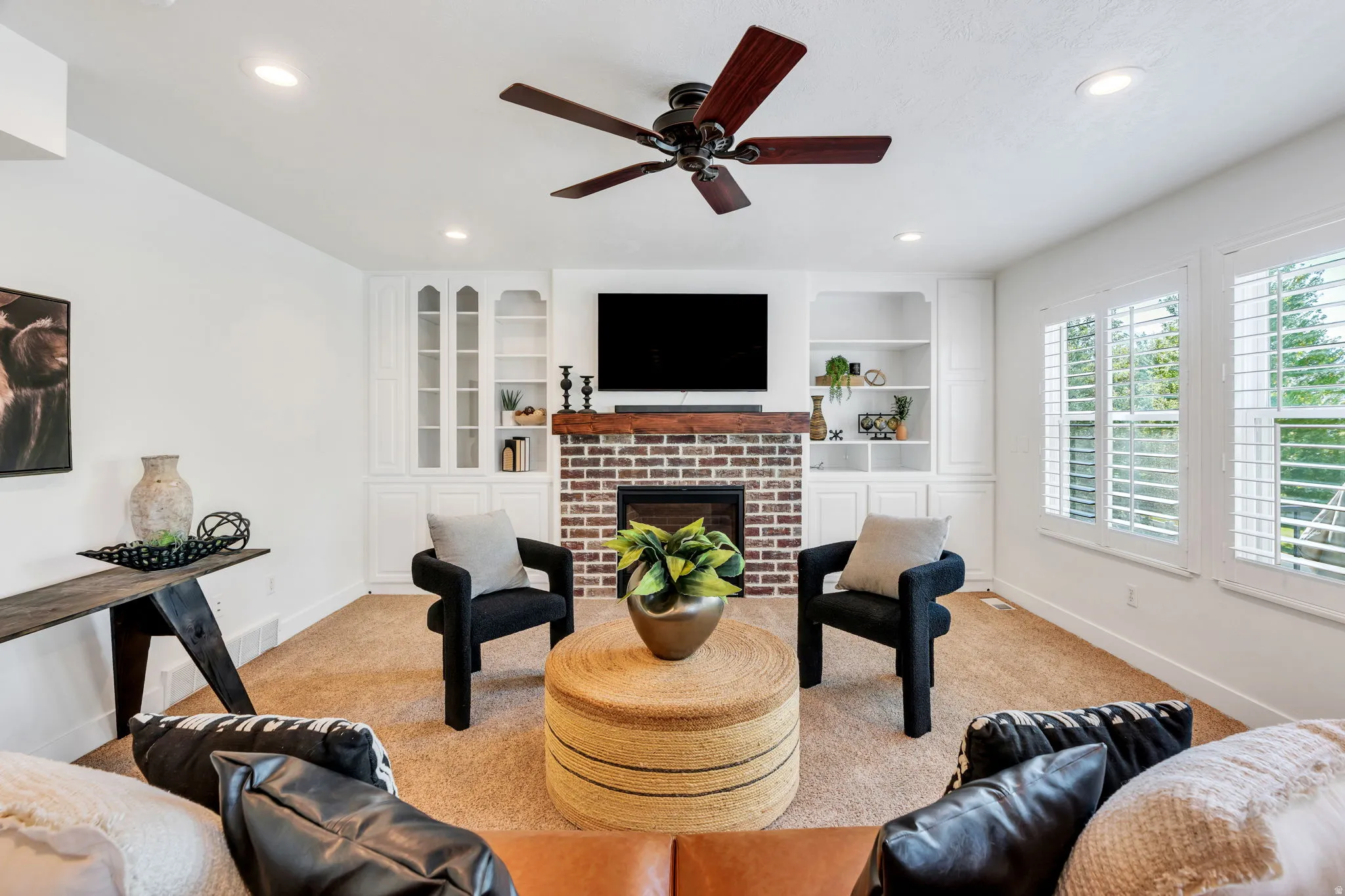 Large great room with gas fireplace and plantation shutters