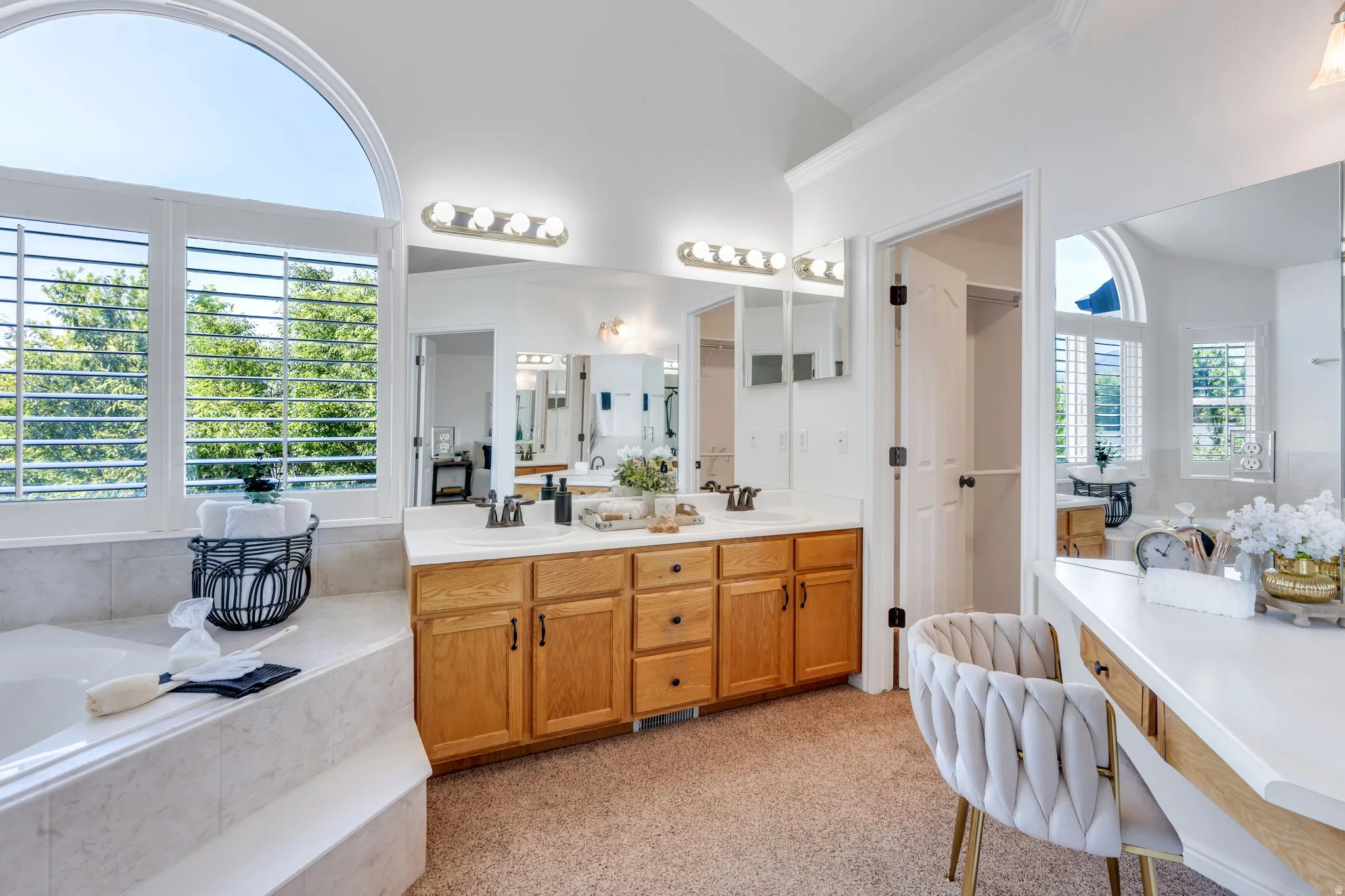 Primary suite bathroom with two sinks, vanity area and separate tub/shower