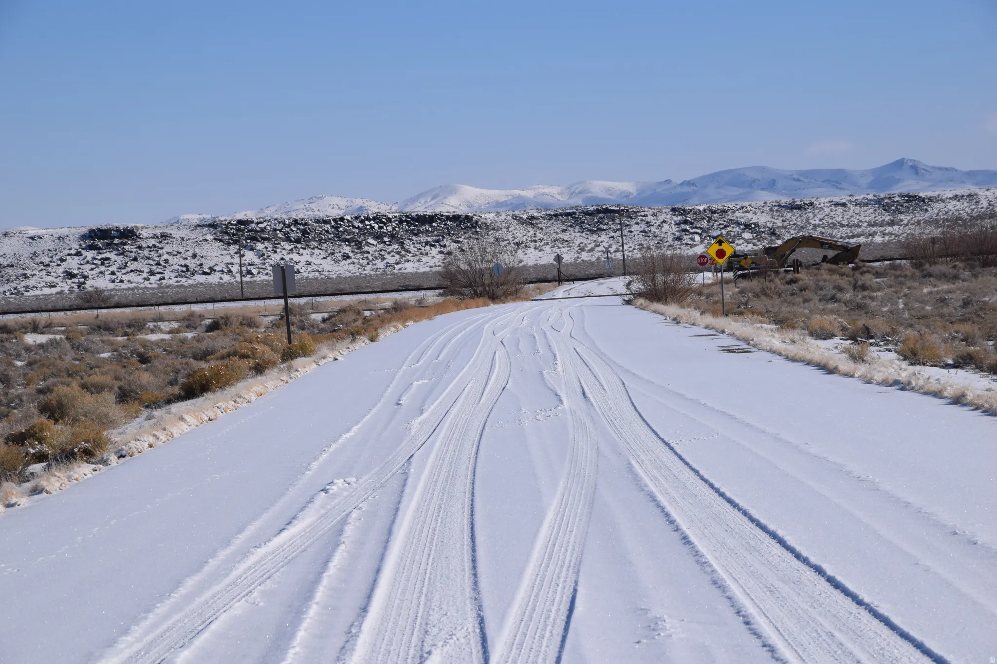View of asphalt road featuring a mountain view and traffic signs