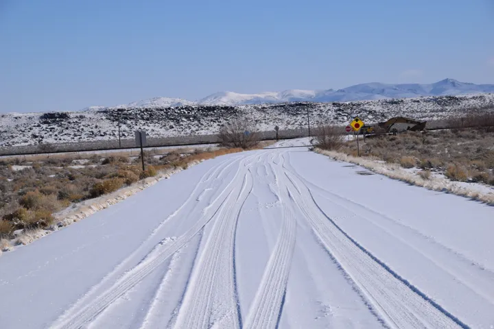 View of asphalt road featuring a mountain view and traffic signs