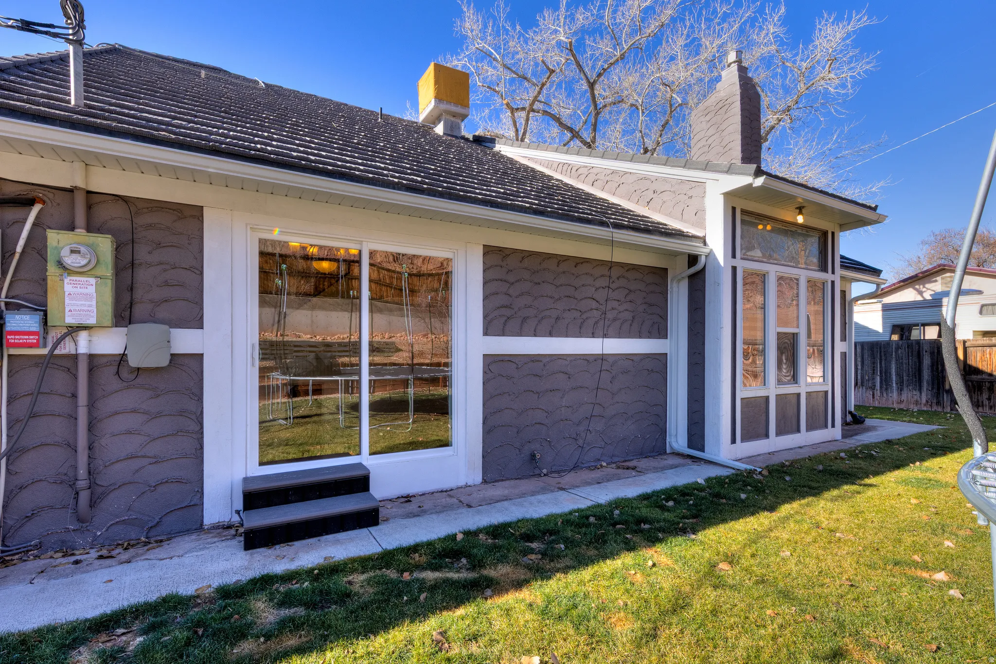 Back of house featuring new sliding glass door and classic windows
