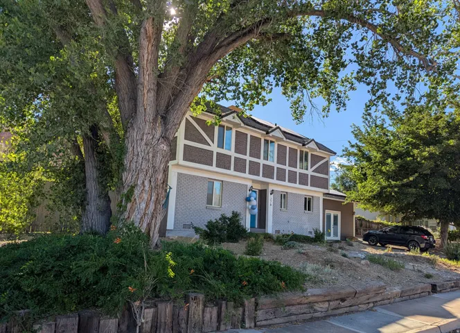 View of front of house featuring roof mounted solar panels, brick & stucco exterior, and french doors