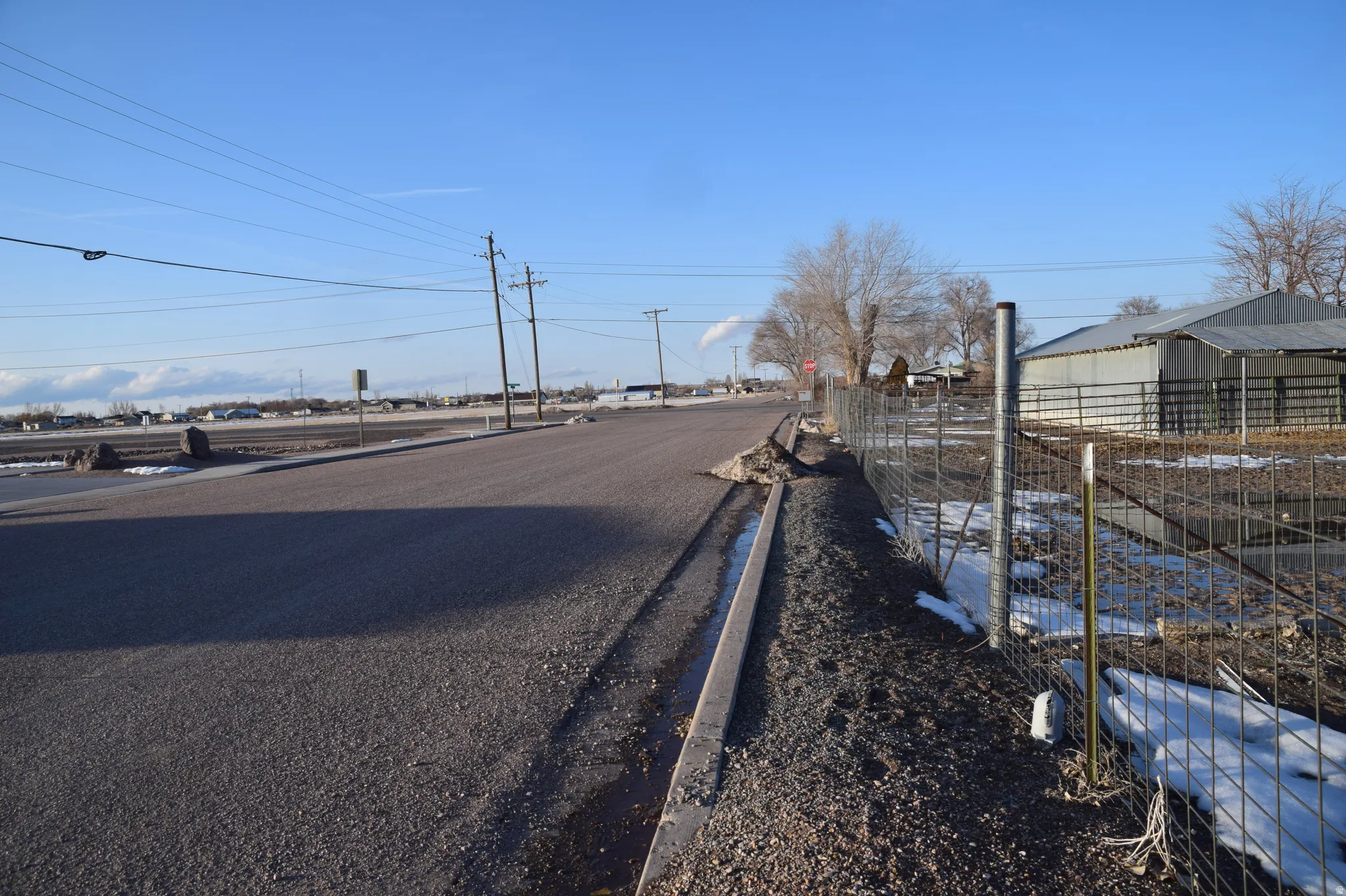 View of asphalt street with curbs and traffic signs