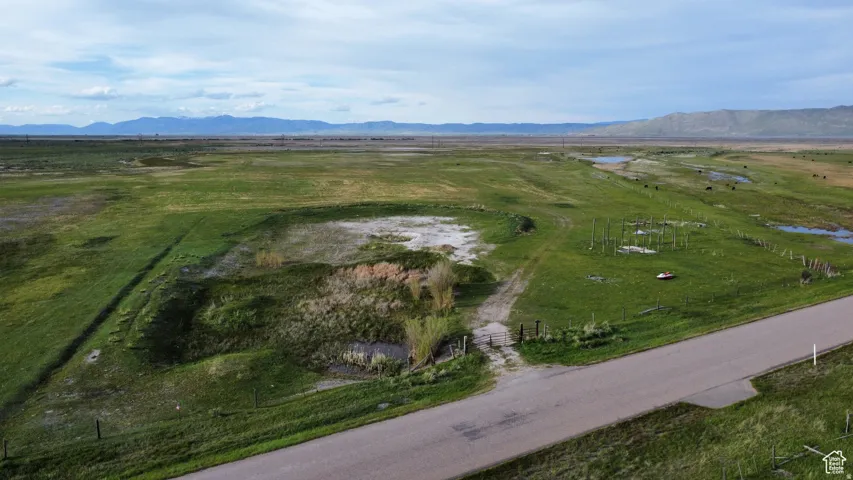 Aerial view of property and surrounding area featuring rural landscape and a mountainous background