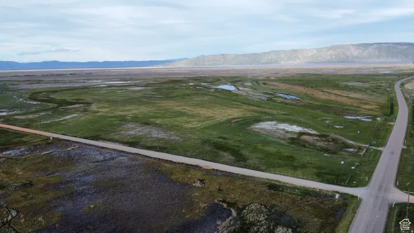 Aerial view of property and surrounding area featuring rural landscape and a mountainous background