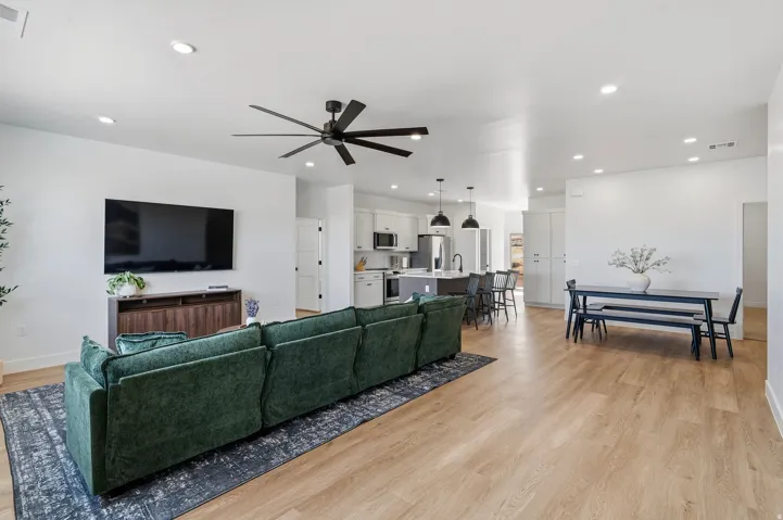 Recessed ceiling lighting, wood-finish flooring, and a ceiling fan with integrated lighting
