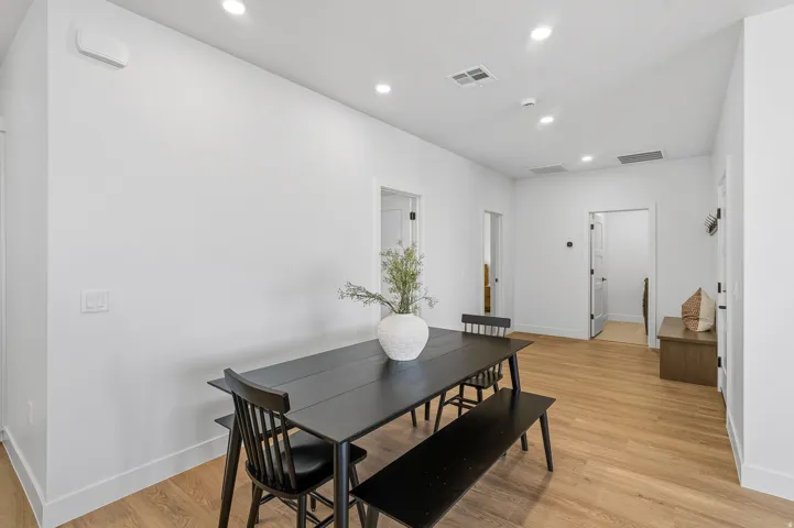 Recessed ceiling lighting, light wood-finish flooring, white walls, and white trim