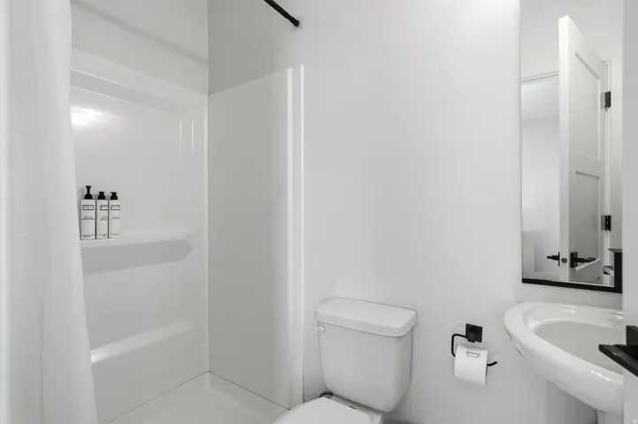 White pedestal sink with black hardware