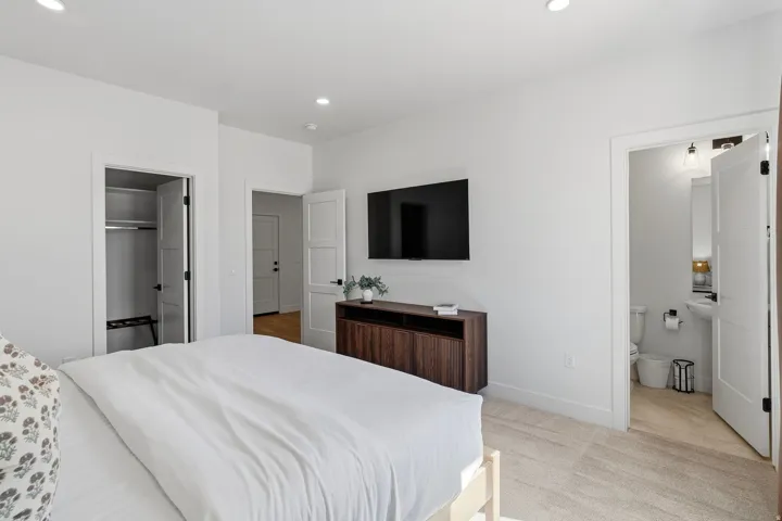 Recessed ceiling lighting, white interior doors, integrated closet shelving, wood-finish console cabinetry, and a pedestal sink