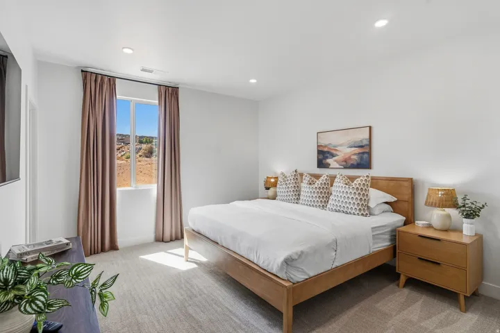 Recessed lighting, light-toned carpeting, ample natural light, and a window with desert scenery