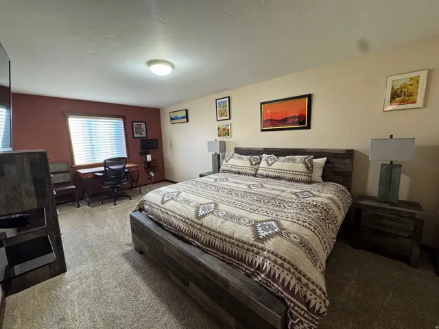 Carpeted bedroom with a desk