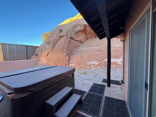 View of patio with a hot tub.  Beautiful sandstone setting