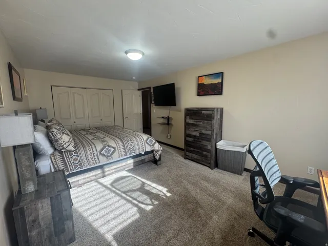 Carpeted bedroom featuring a closet and baseboards
