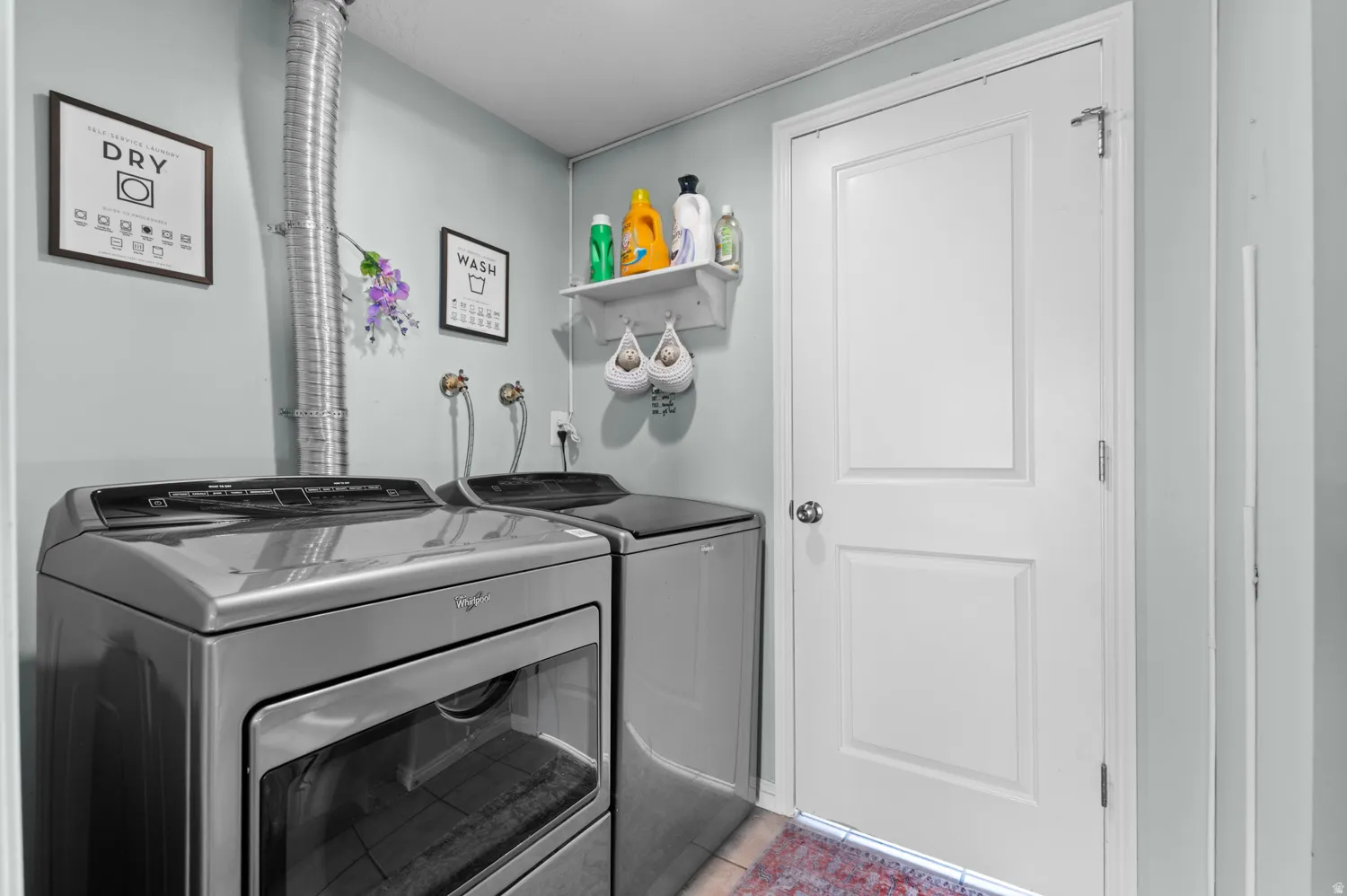 Washroom featuring washer and clothes dryer and light tile patterned floors