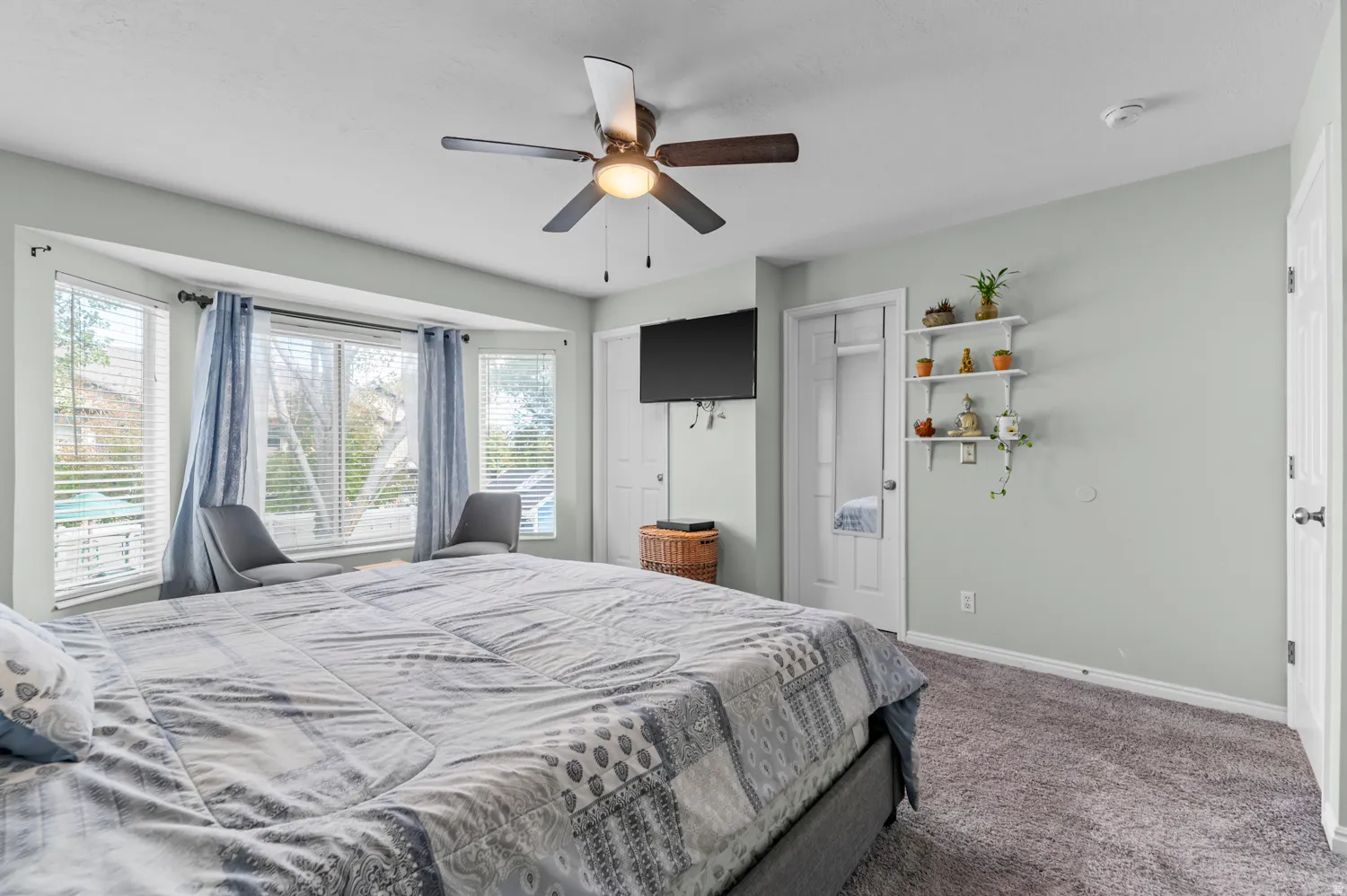 Carpeted bedroom featuring a ceiling fan and a closet