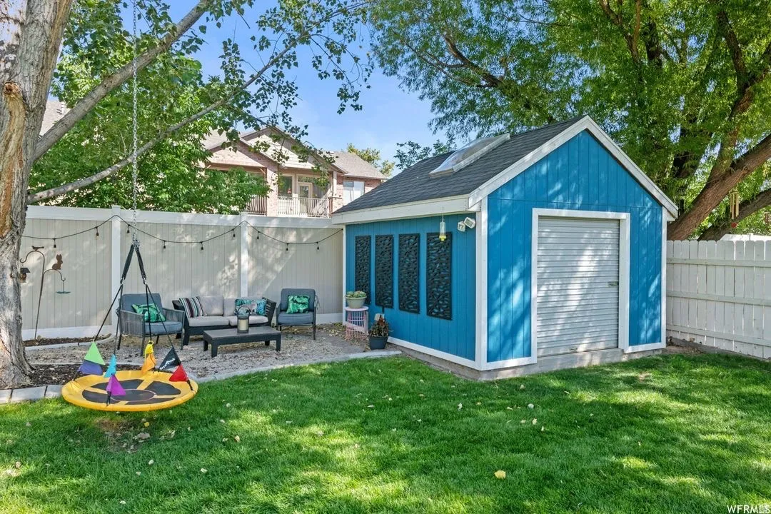 View of outbuilding with an outdoor hangout area and a fenced backyard