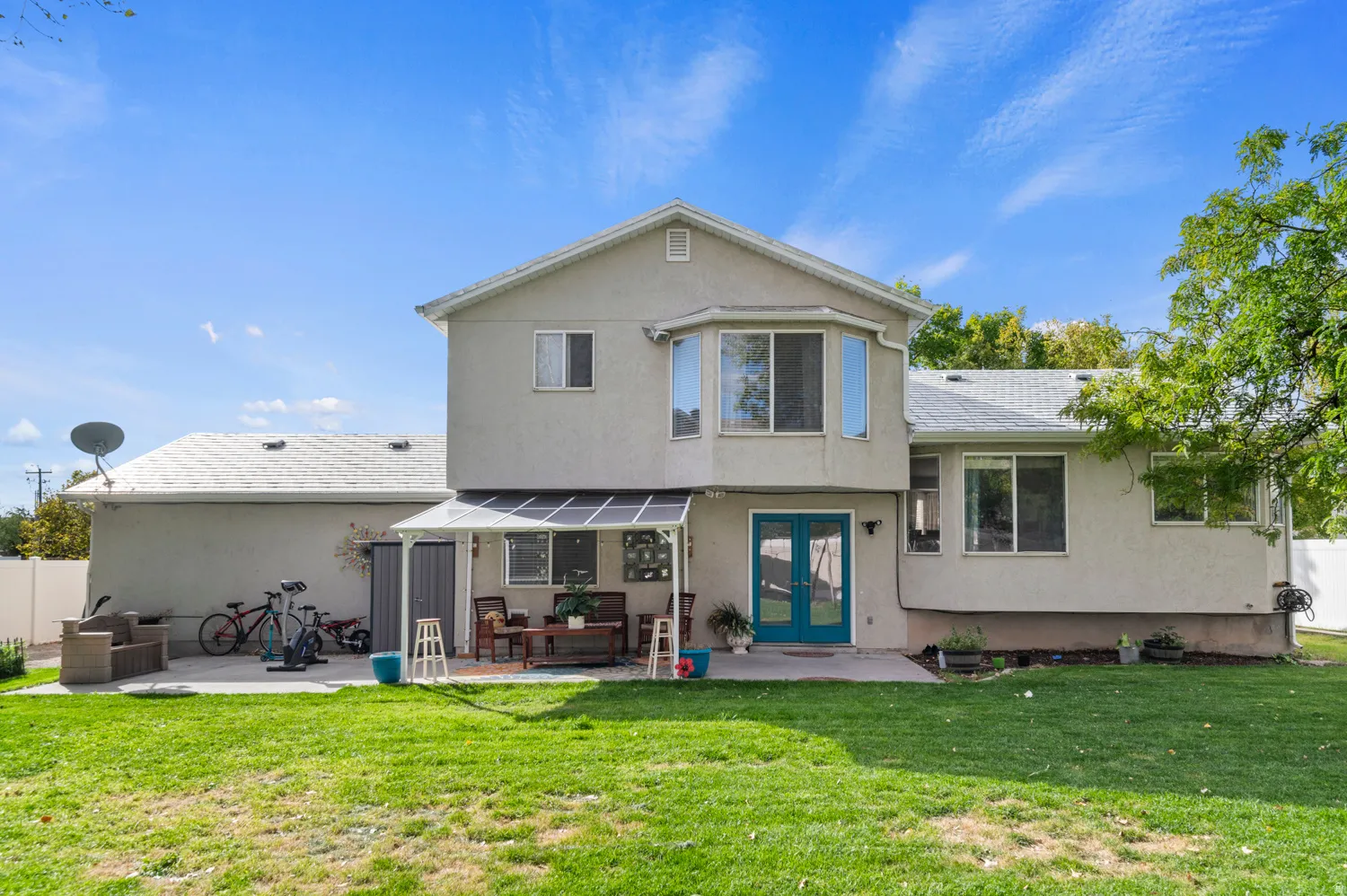 Back of property featuring a patio area, stucco siding, french doors, and roof with shingles