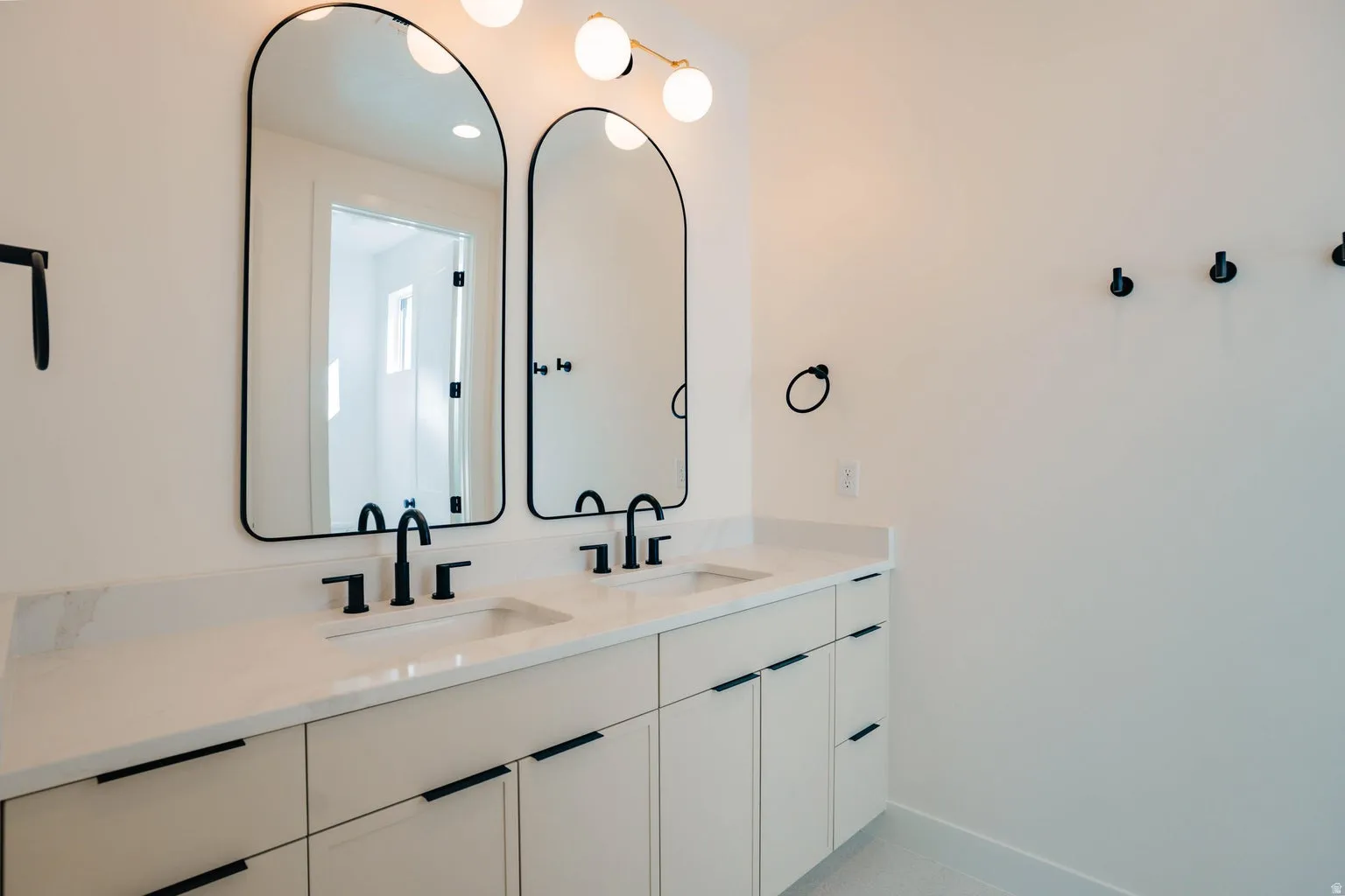 Bathroom with double vanity and baseboards