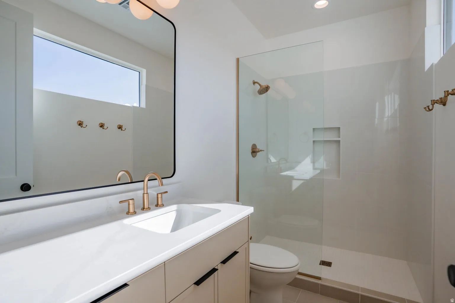 Bathroom featuring vanity, a walk in shower, and light tile patterned floors