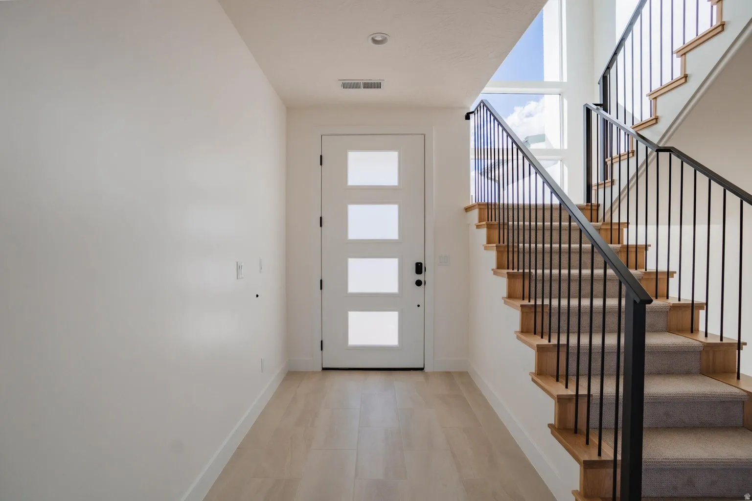 Foyer featuring baseboards and stairway