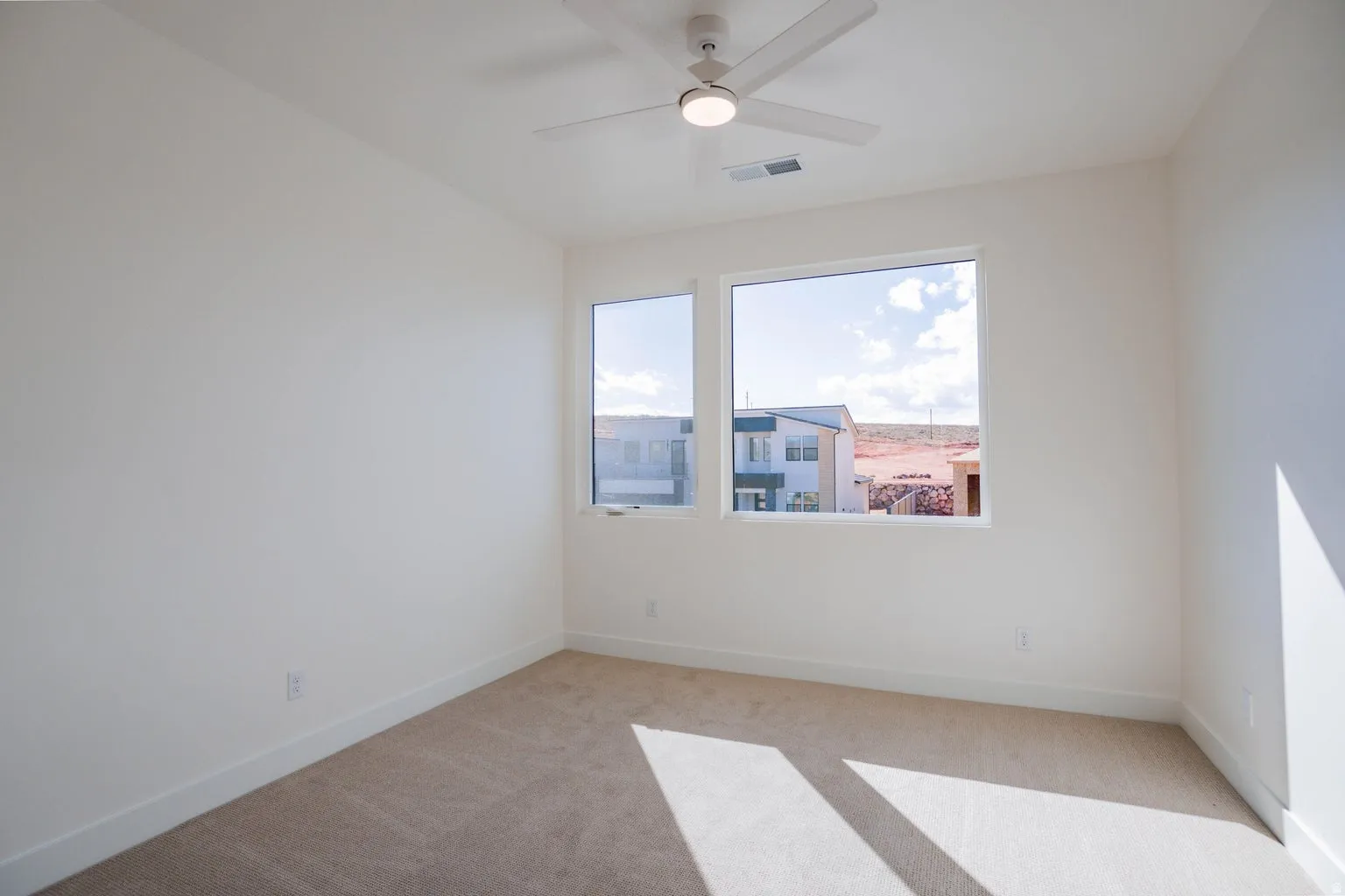 Unfurnished room featuring light colored carpet and ceiling fan
