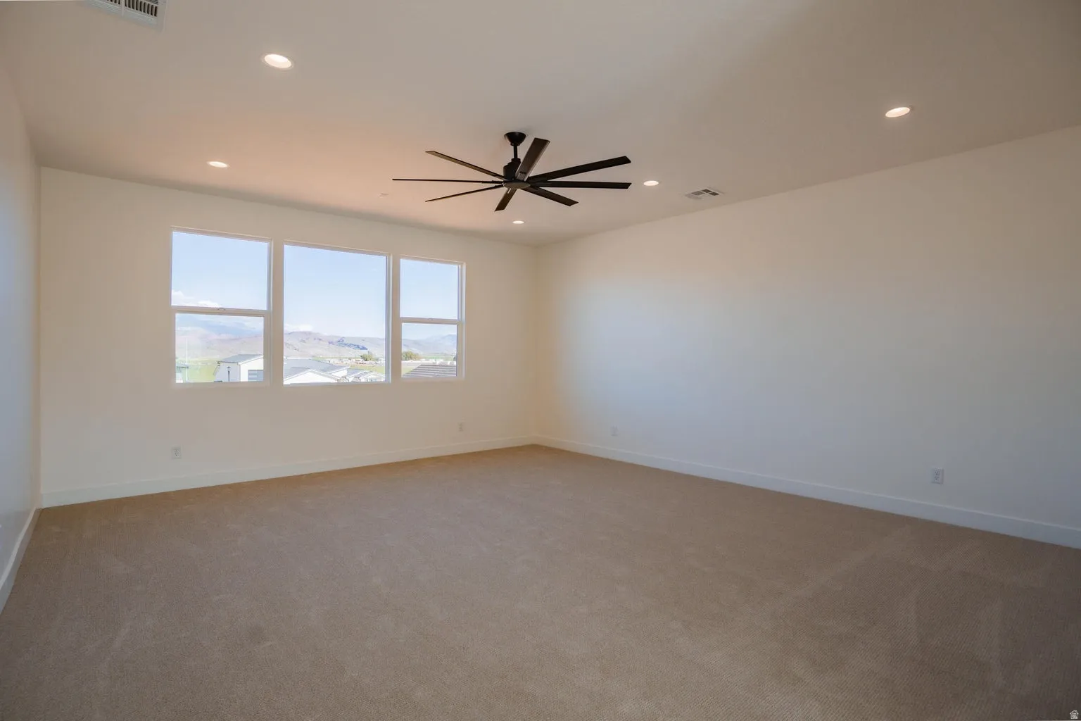 Spare room featuring light carpet, recessed lighting, and ceiling fan