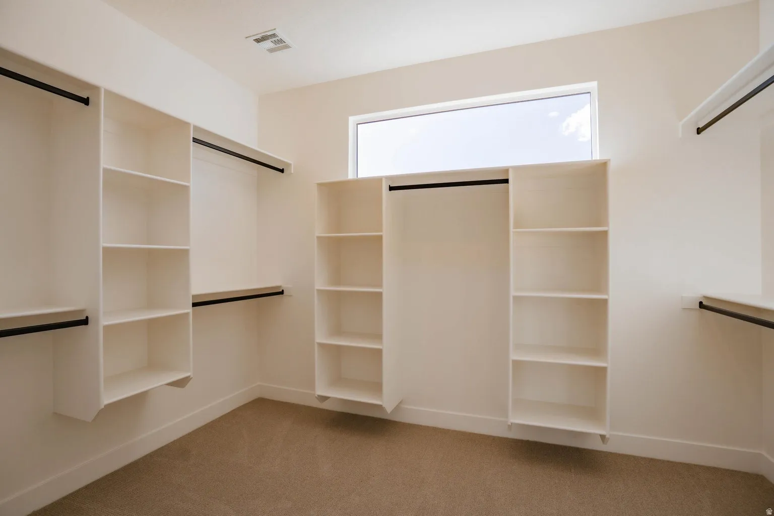 Spacious closet with light colored carpet
