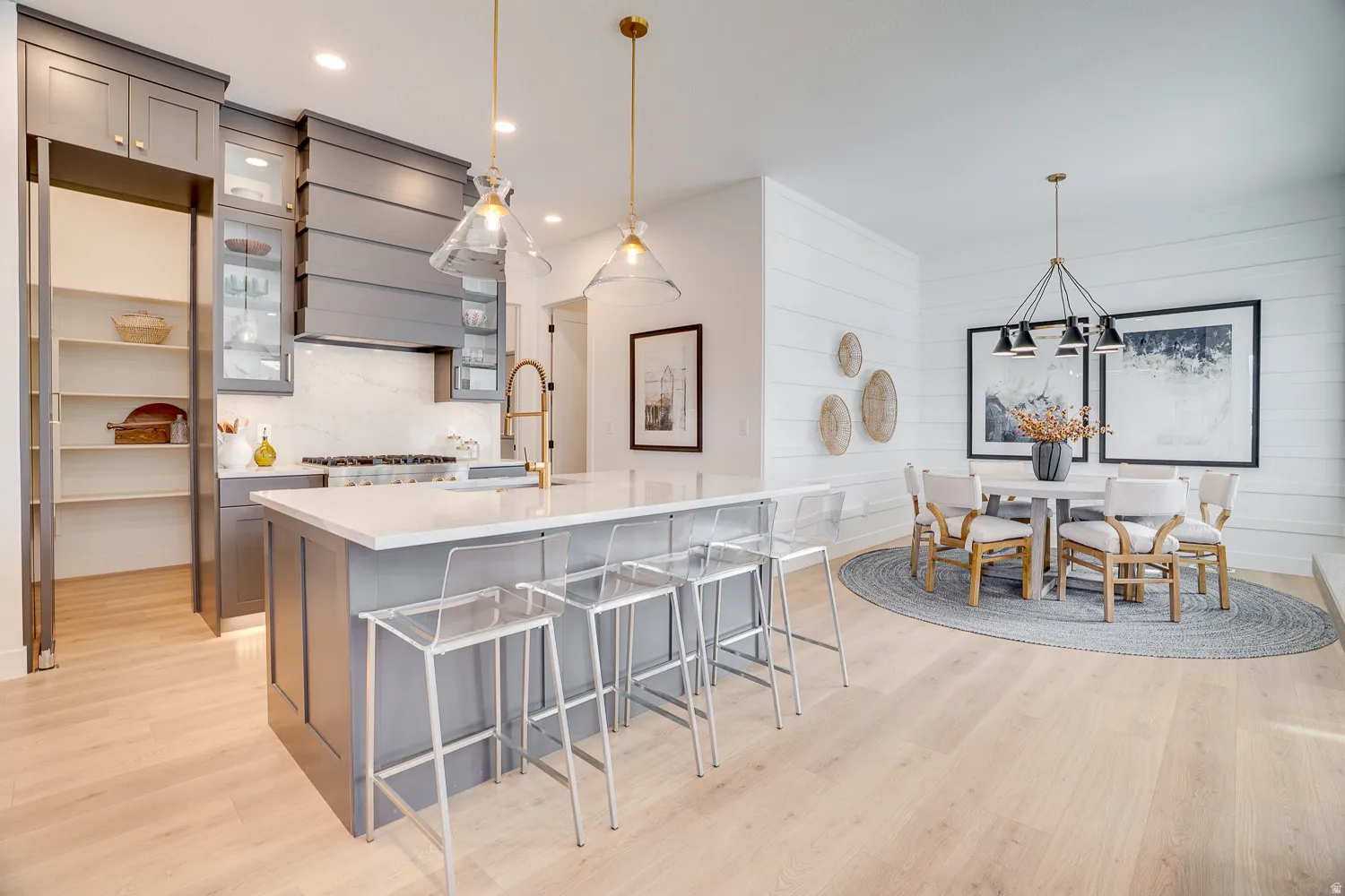 Kitchen with gray cabinets, a breakfast bar, hanging light fixtures, light wood-style floors, and recessed lighting