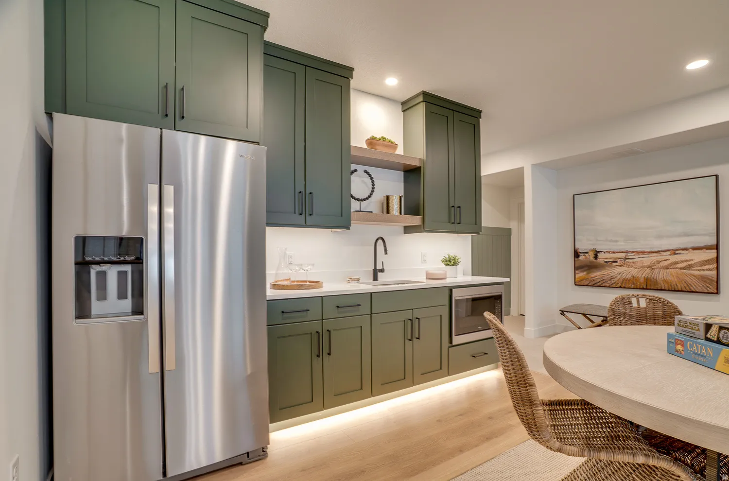 Kitchen with green cabinetry, stainless steel appliances, open shelves, light wood-style flooring, and recessed lighting
