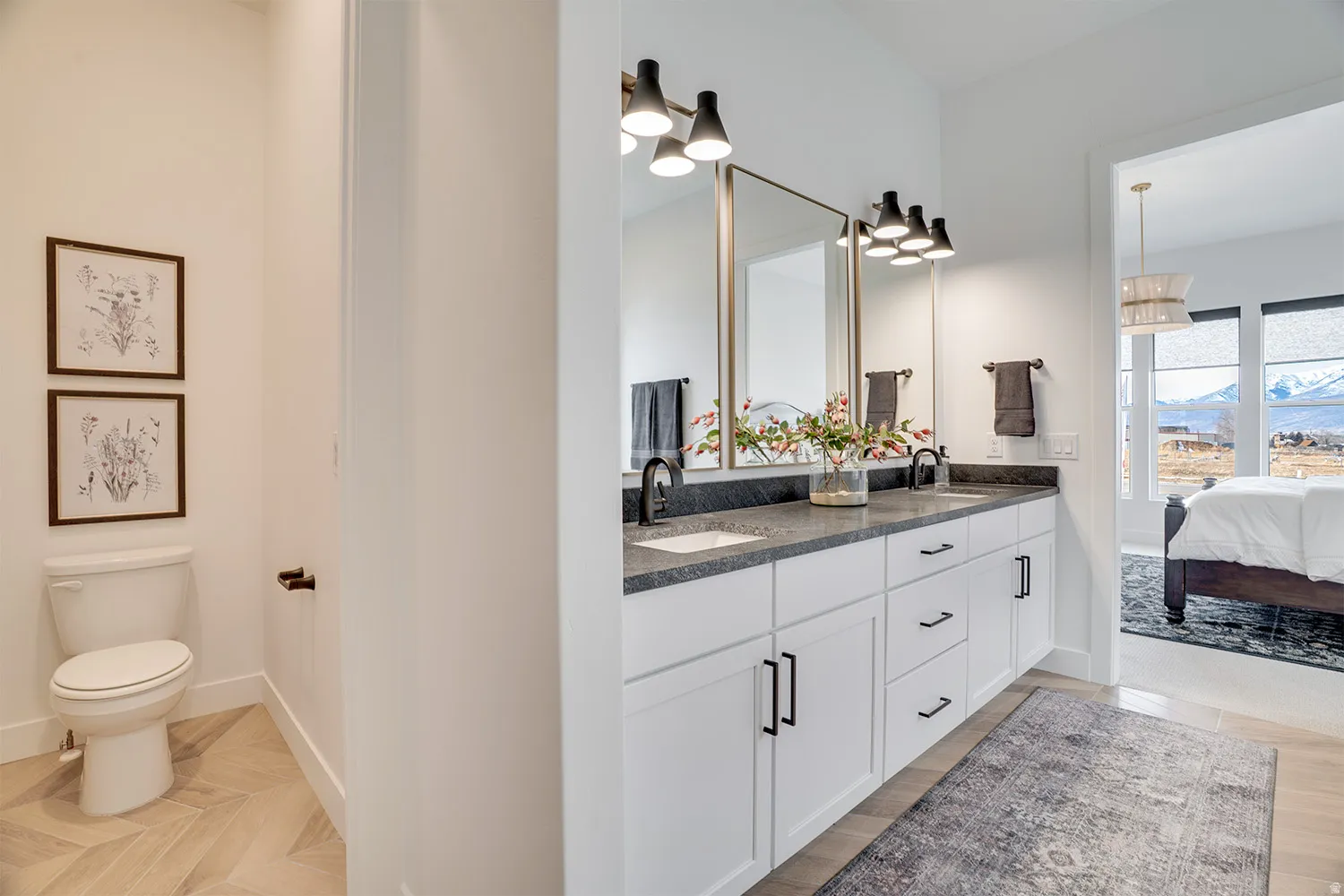 Ensuite bathroom featuring double vanity, parquet flooring, and a mountain view