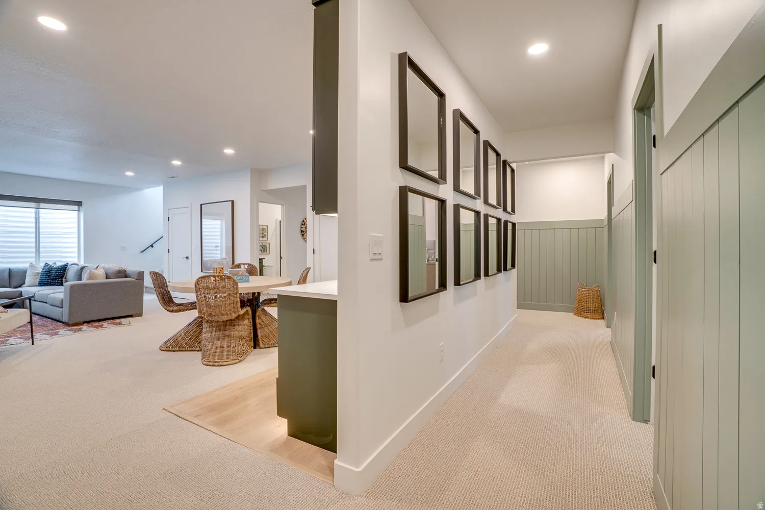 Hall with light colored carpet and recessed lighting