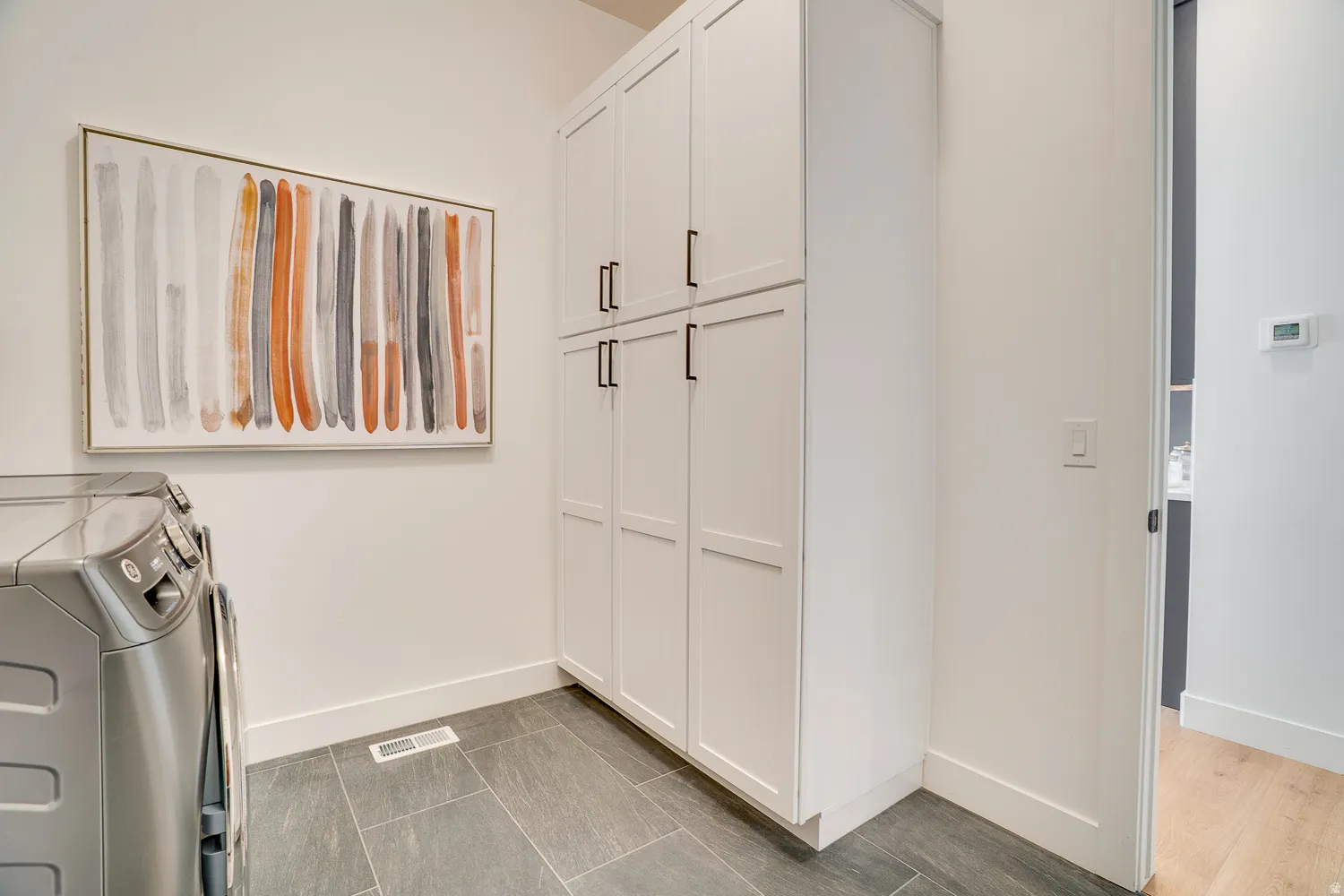 Washroom with washer and dryer and baseboards