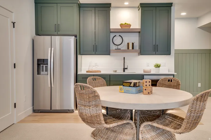 Kitchen featuring green cabinets, stainless steel fridge, open shelves, light wood finished floors, and recessed lighting