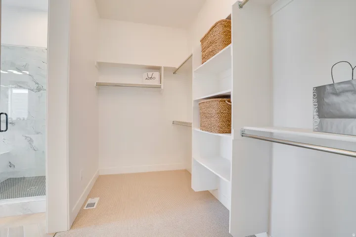 Spacious closet with light colored carpet