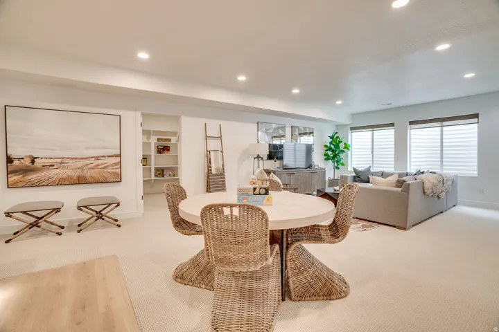 Carpeted dining room with built in features and recessed lighting