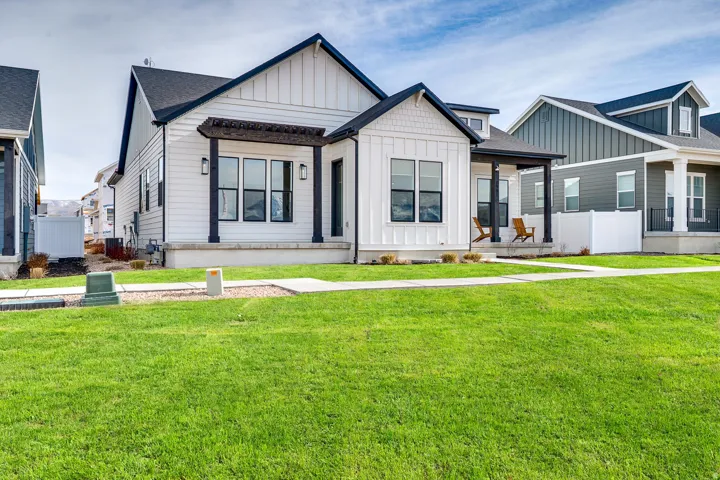 Modern inspired farmhouse with board and batten siding, a porch, and roof with shingles