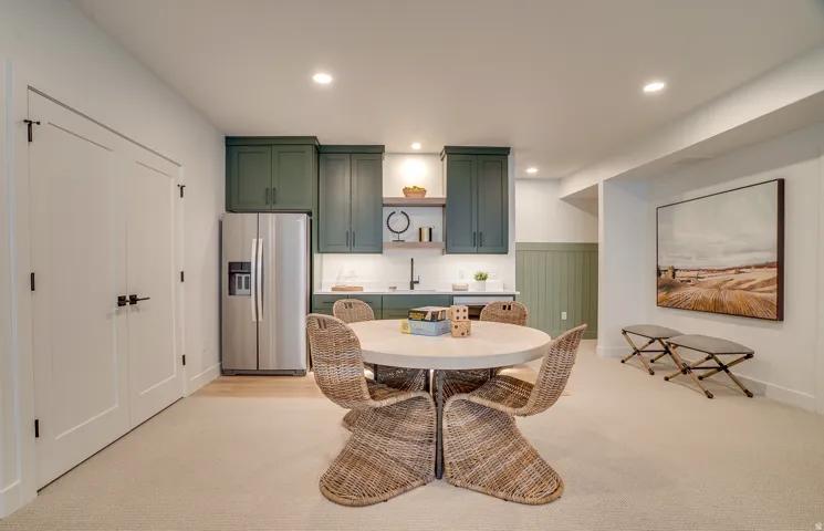 Dining space featuring light colored carpet, wainscoting, and recessed lighting