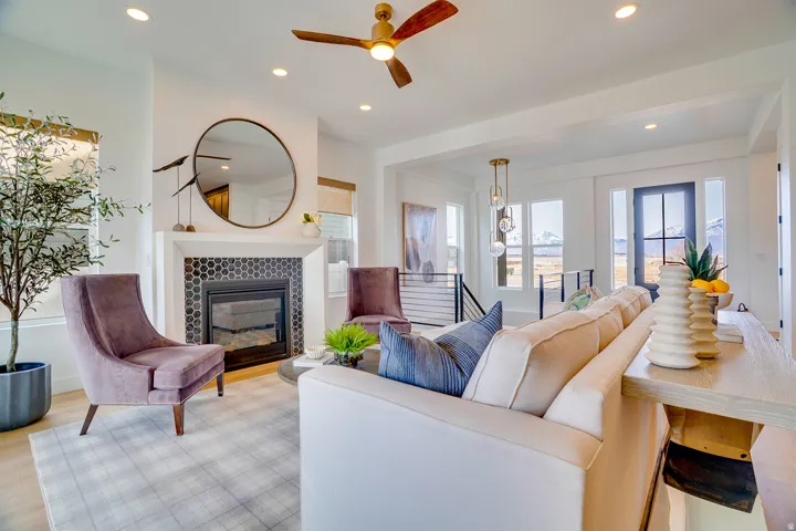 Living room with healthy amount of natural light, a tile fireplace, ceiling fan, recessed lighting, and light wood-type flooring