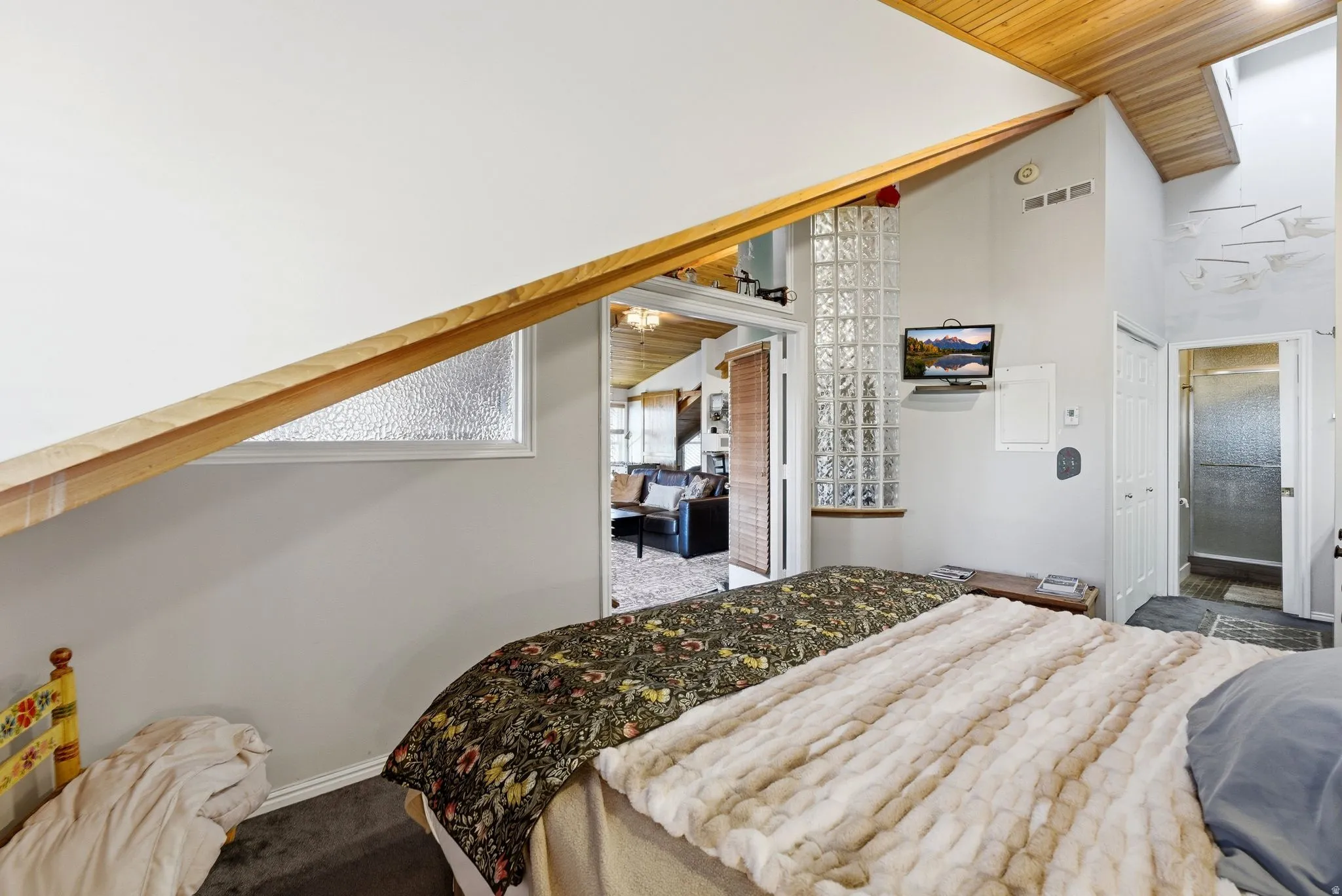 Bedroom with wood ceiling, carpet, high vaulted ceiling, and ensuite bathroom