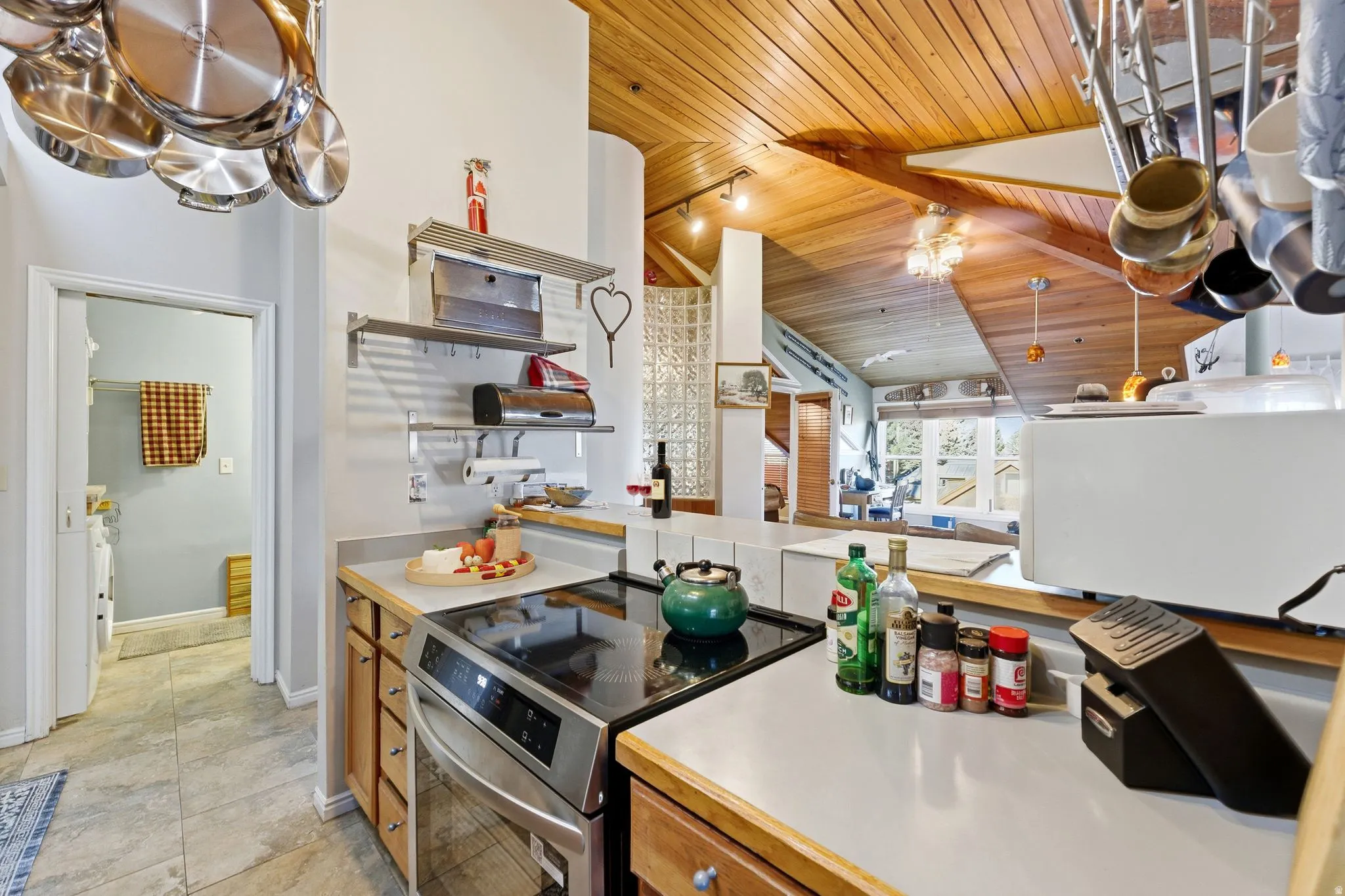 Kitchen with light countertops, electric range, open shelves, wood ceiling, and lofted ceiling